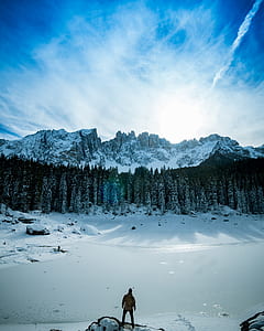 man standing on the foot of the mountain filled with snow thumbnail