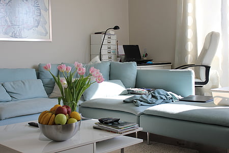 grey sectional couch with flowers on center table thumbnail