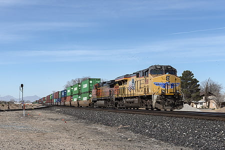 yellow, red, and green train on railway during day time thumbnail