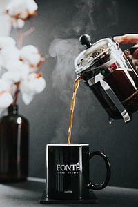 person holding coffee pitcher refilling on mug thumbnail
