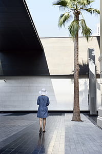 woman standing beside palm tree thumbnail