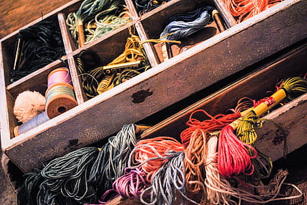 assorted-color yarn lot on wooden crate thumbnail