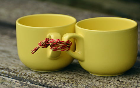 two yellow ceramic teacups tied together thumbnail