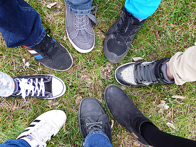 eight people sticking out right foot forming a circle on green grass thumbnail