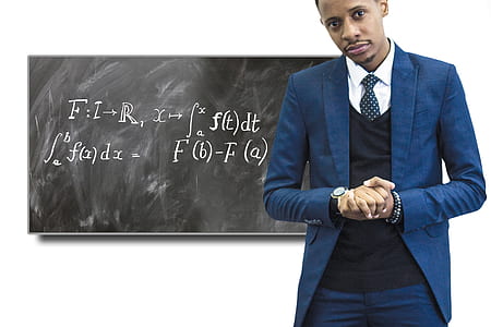 man in blue suit jacket in front of blackboard thumbnail