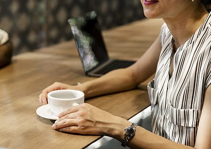 Woman Holding White Mug on Saucer thumbnail