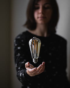 woman standing throwing bulb on hand thumbnail
