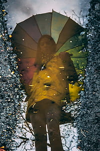 woman holding umbrella standing reflected glossy water during daytime thumbnail