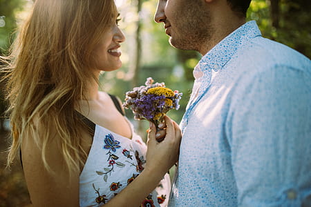 two couple holding flower during daytime thumbnail