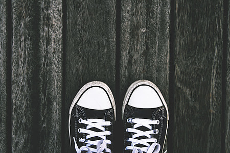 Persons feet and sneaker shoes on wooden panels thumbnail