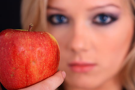 selective focus shot of apple near woman's face thumbnail