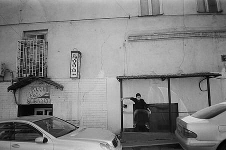 Grayscale Photo of Man Sitting on Bench thumbnail