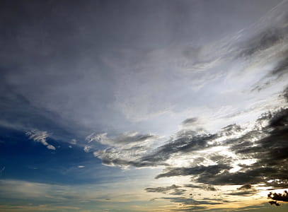 Skyscape of sunset sky with sparsly scattered dark clouds thumbnail