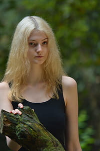 Woman in Black Tank Top While Her Right Hand Is Holding a Tree Branch thumbnail