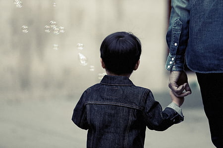 selective focus photography of boy holding hand of her mother thumbnail