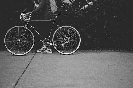 grayscale photo of person holding road bicycle thumbnail