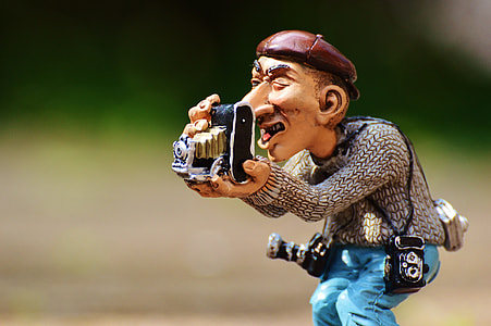 man holding camera figurine thumbnail