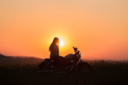 silhouette of woman riding motorcycle during sunset thumbnail