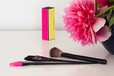 three black handled makeup brushes beside pink flower thumbnail
