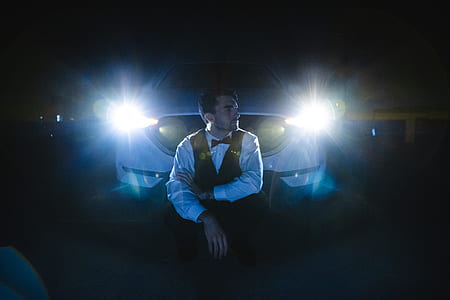 man sitting in front of white car thumbnail