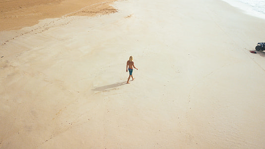 person walking on sand in aerial photography thumbnail