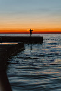 The man is looking at the sunset by the sea thumbnail