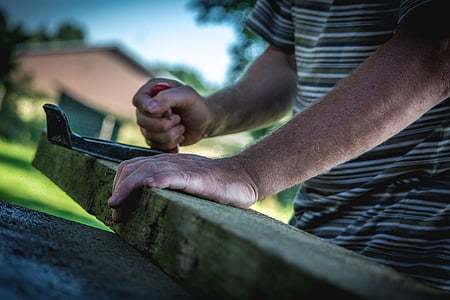 person holding brown wooden beam during daytime thumbnail