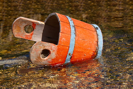 orange wooden bucket on body of water thumbnail