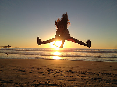girl jumps on seashore during sunset thumbnail