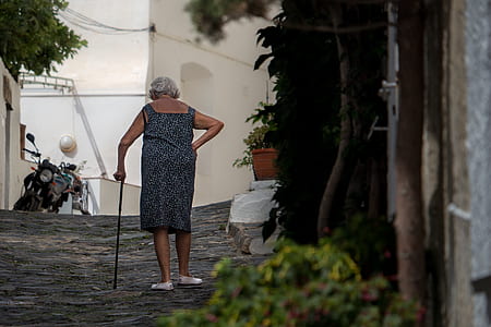 woman standing on ground while holding walking cane thumbnail