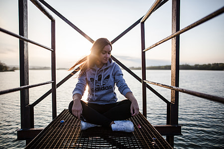 woman sitting on gray metal dock during daytime thumbnail