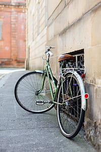 green and grey city bike parked near black metal rails thumbnail