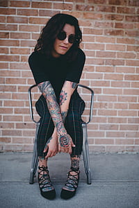 woman sitting on chair beside concrete wall brick thumbnail