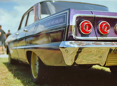 focus photography of classic purple sedan's taillight thumbnail