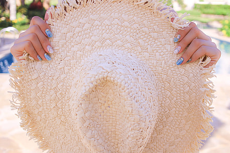 person holding white straw hat thumbnail
