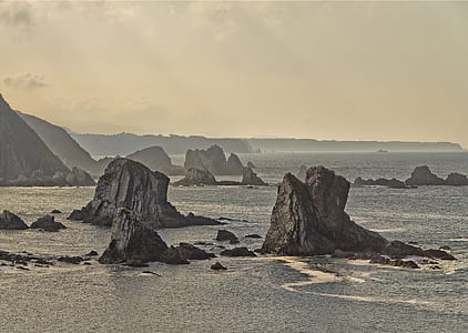 rock mountains on body of water thumbnail