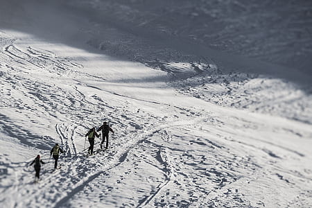 four people walking on snow during daytime thumbnail