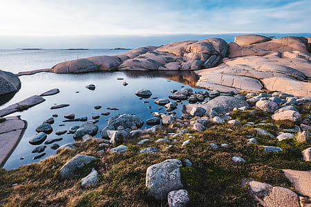 body of water beside boulders thumbnail