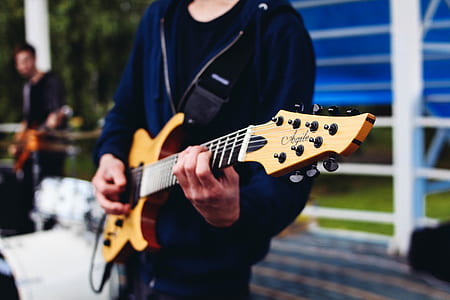 person holding brown guitar thumbnail