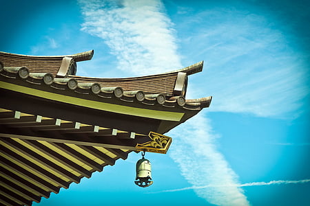 brown wooden roof with brass-colored bell at daytime thumbnail