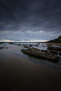 rock coastal under gray clouds thumbnail