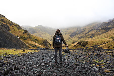 person holding bag looking at mountain ranges thumbnail