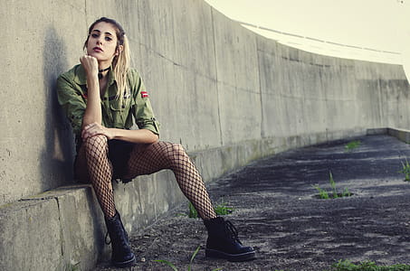 Woman Sits Besides Gray Concrete Wall thumbnail