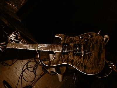 brown and black electric guitar on brown surface thumbnail