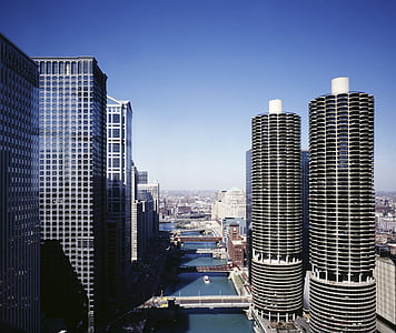 high rise buildings near body of water under blue sky thumbnail