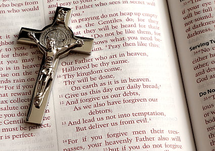 silver-colored crucifix on top of printed book thumbnail