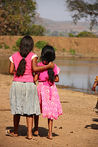 girl holding another girl by waterhole thumbnail