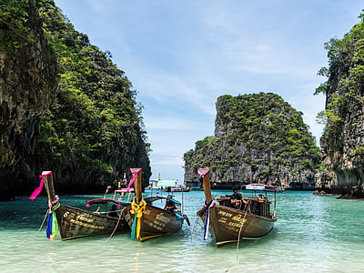 photo of three brown motorboats dock on seashore thumbnail