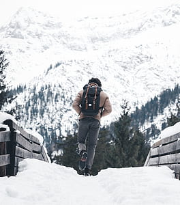 person walking towards snow covered mountain thumbnail