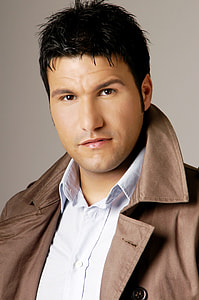 man in white button-up shirt with brown jacket thumbnail